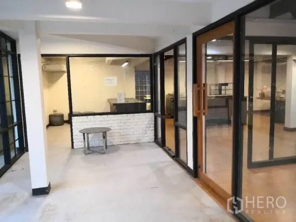 พื้นที่ขายปลีก ให้เช่าในKhlong Toei, Bangkok - โถงต้อนรับ ผนังกระจกกรอบอลูมิเนียมสีดำและประตูไม้เข้าสู่โซนหลัก.