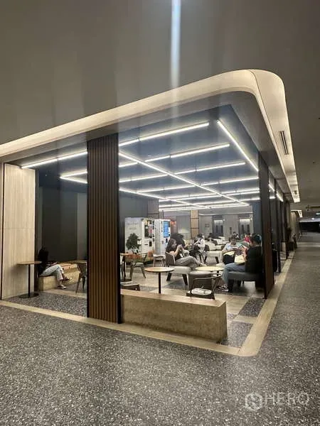 零售空间 出租 - 带玻璃分隔的零售座位区，网格LED灯、沙发及木质立柱，临宽敞走廊。