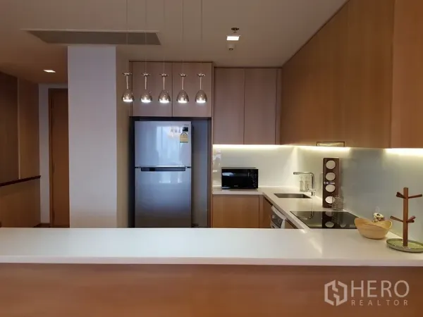 公寓 出租在Watthana, Bangkok - 现代厨房，吊灯、不锈钢冰箱与白色台面