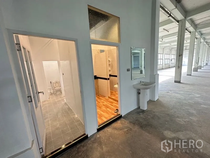Office Space for rent in Bang Sao Thong, Samut Prakan - Twin restroom entrances off the main office hall with mirror and sink.