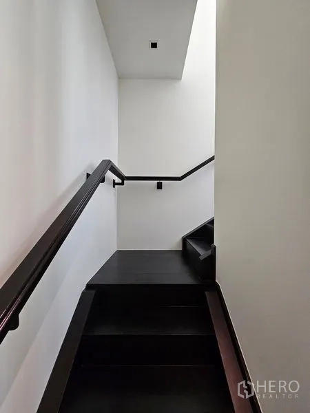 Condominium for rent - Minimal black staircase with handrail leading to the upper level.
