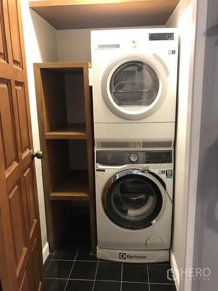 公寓 出租在Bang Rak, Bangkok - 紧凑洗衣区，叠放式伊莱克斯洗衣机与烘干机及开放式搁架。