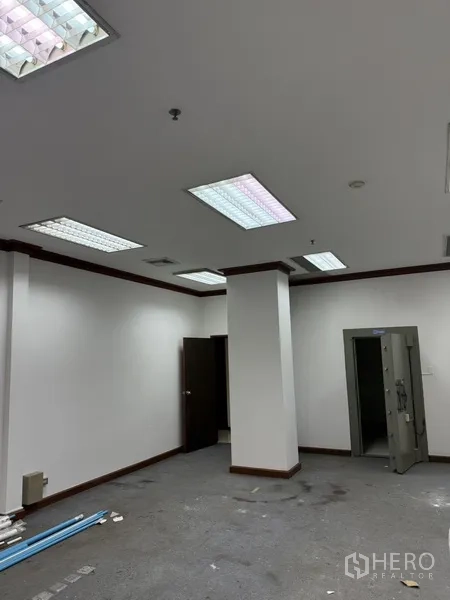 零售空间 出租在Sathon, Bangkok - 开放办公区，天花板荧光灯，可见保险库入口。