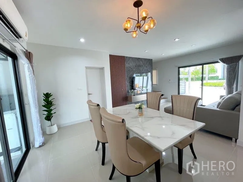 Townhouse for rent in Bang Phli, Samut Prakan - View from dining toward living room with large windows bringing in garden light.