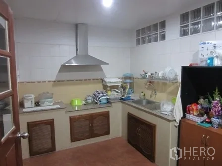 Home Office for rent or sale in Wang Thonglang, Bangkok - Practical Thai kitchen with range hood, sink and tiled walls.