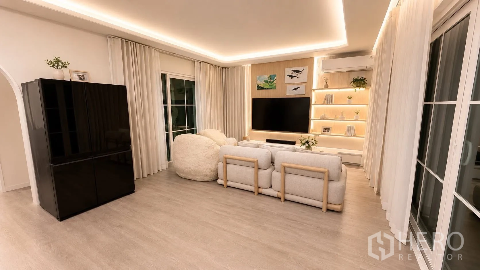 Detached House for rent or sale in Bang Phli, Samut Prakan - Living room with TV wall, LED-lit display shelves, large windows, and sofa seating.