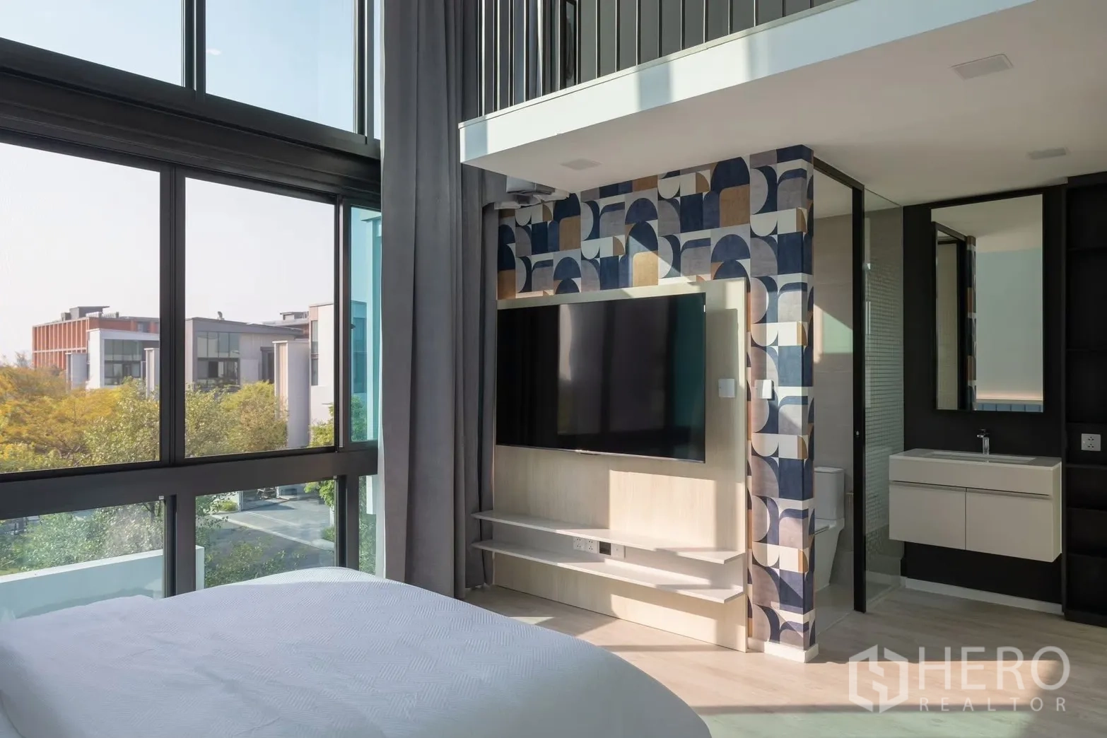 Detached House for rent in Saphan Sung, Bangkok - Corner bedroom with double-height glazing, TV wall, and ensuite vanity.