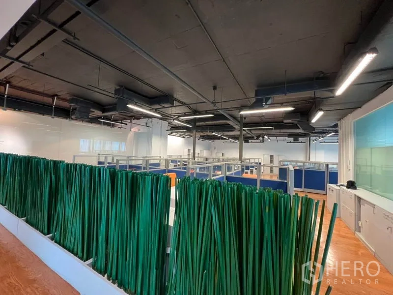 Office Space for rent in Khlong Toei, Bangkok - Open workspace overview with a green decorative divider and industrial-style ceiling.