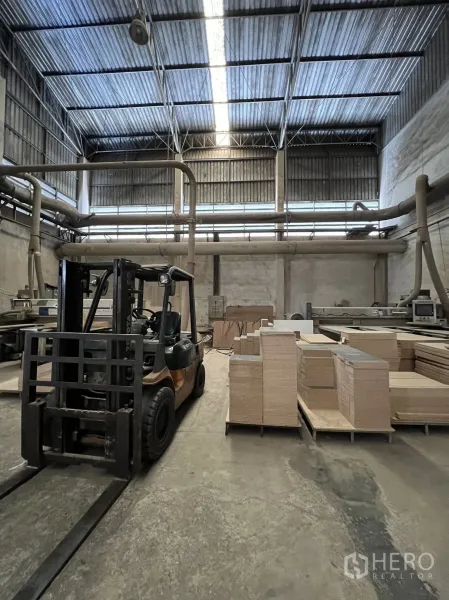 工厂 出租或出售在Sai Noi, Nonthaburi - 叉车在车间作业区，配吸尘管道与成堆板材