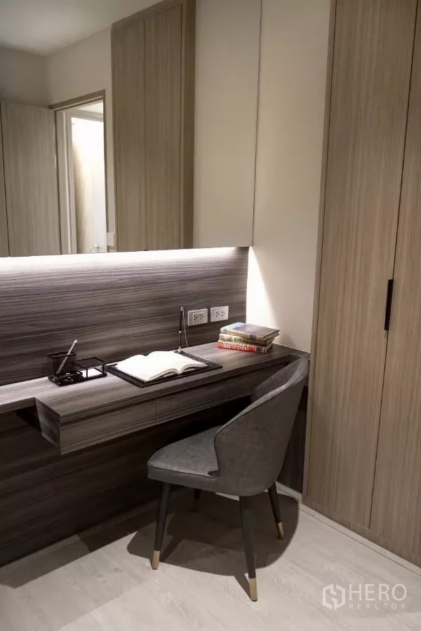 Condominium for rent in Watthana, Bangkok - Close‑up of built‑in workspace with wood cabinetry, task lighting and upholstered chair.