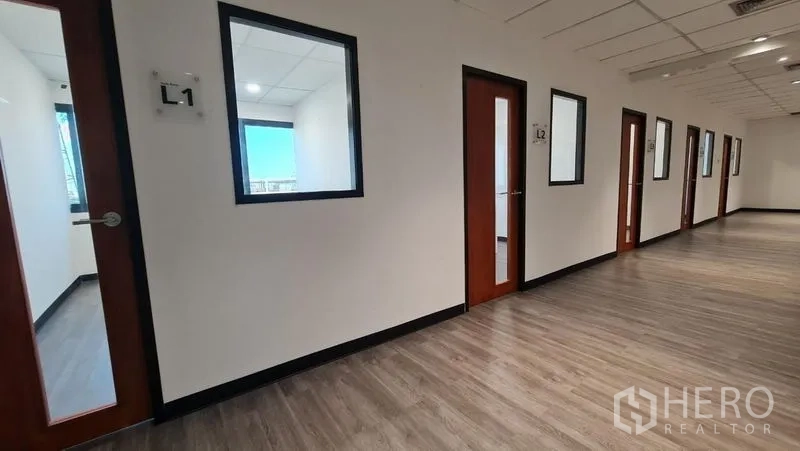 Office Space for rent in Watthana, Bangkok - Corridor lined with numbered private offices and interior windows.