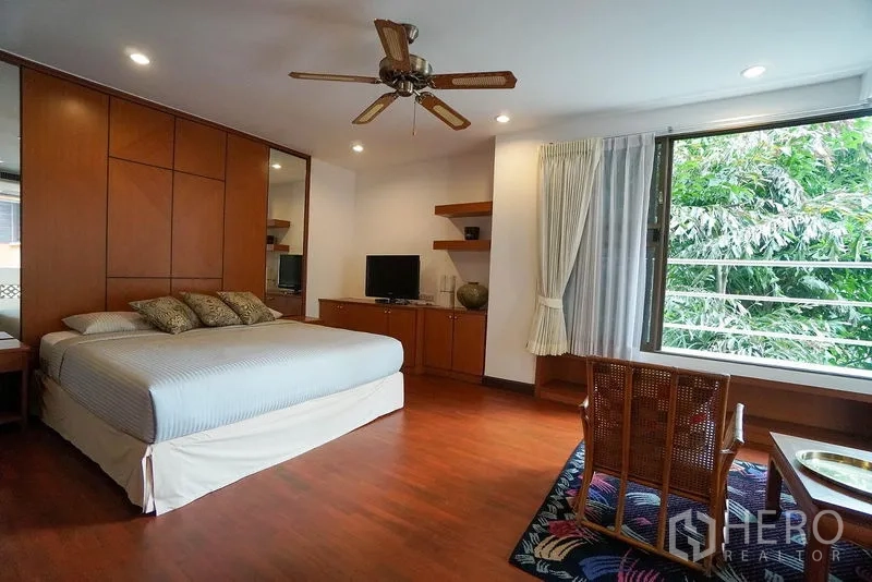 อพาร์ทเมนท์ ให้เช่าในWatthana, Bangkok - ห้องนอนที่สองพร้อมหน้าต่างบานใหญ่ ชุดตู้ทีวีบิวท์อิน และพื้นไม้.