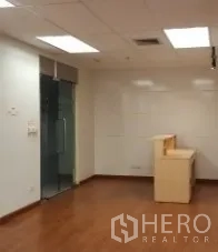 Office Space for rent in Bang Rak, Bangkok - Reception nook and glass door entrance with white walls and wooden floors in an office space.