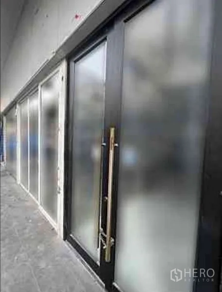 零售空间 出租在Watthana, Bangkok - 磨砂玻璃入口特写，黑色门框与细长金色把手。