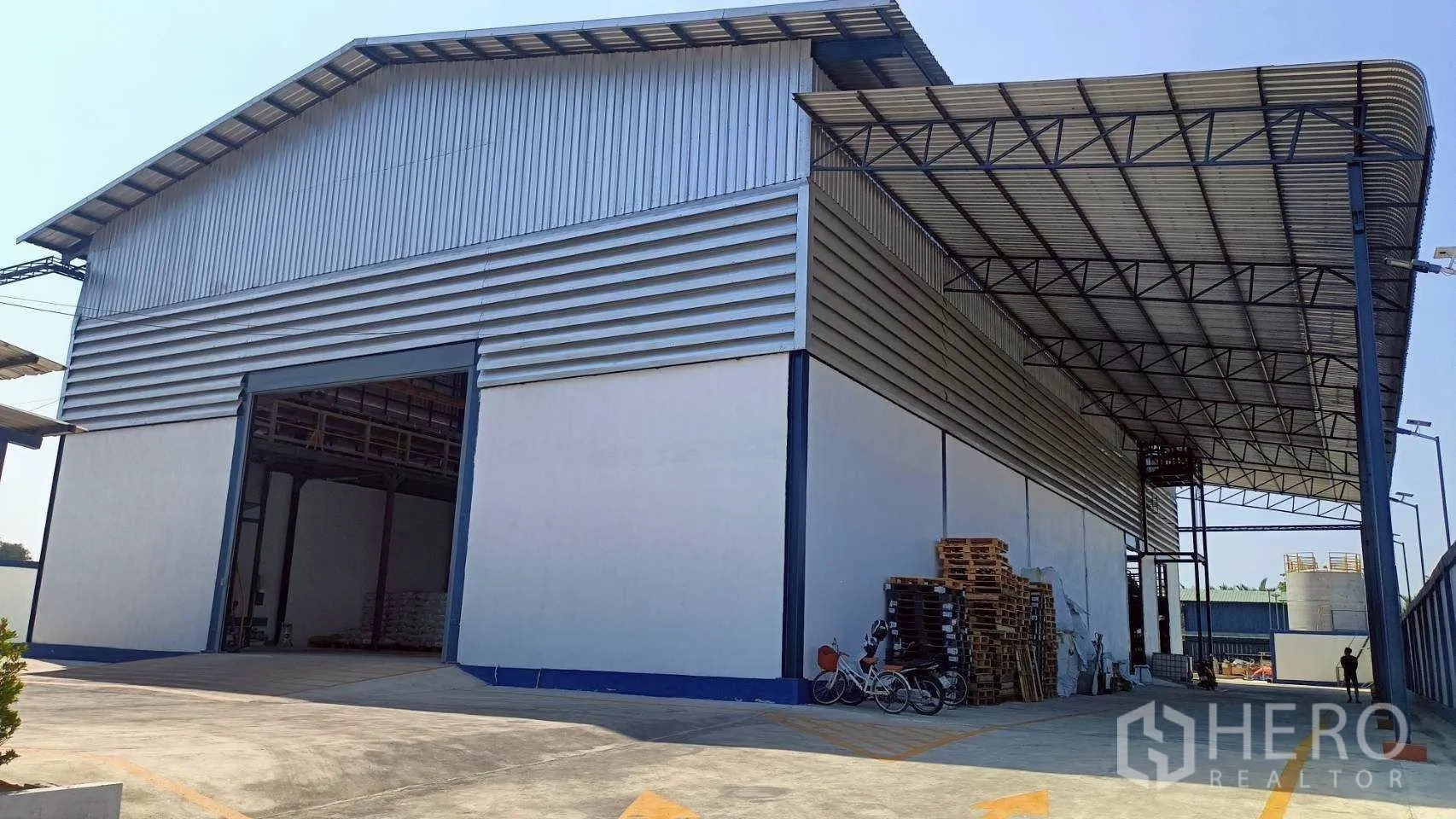 โรงงาน for rent or sale in Mueang Samut Sakhon, Samut Sakhon - หลังคาคลุมสำหรับโหลดสินค้าข้างโกดังพร้อมประตูบานใหญ่และพาเลต