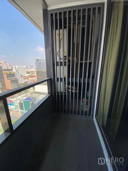 Condominium for rent in Bang Rak, Bangkok - Private balcony with railing and service louver overlooking the Bangkok skyline.