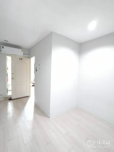 零售空间 出租在Phaya Thai, Bangkok - D2门旁的小房间，白墙、浅木地板并配空调。