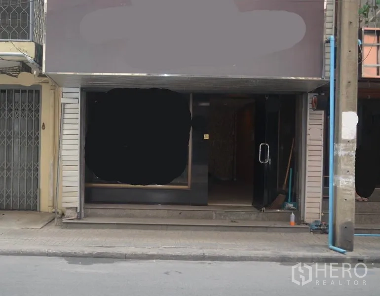 อาคารพาณิชย์ ให้เช่าในKhlong Toei, Bangkok - หน้าร้านชั้นล่างของอาคารพาณิชย์พร้อมกระจกโชว์และประตูกระจก ติดทางเท้าและเสาไฟ