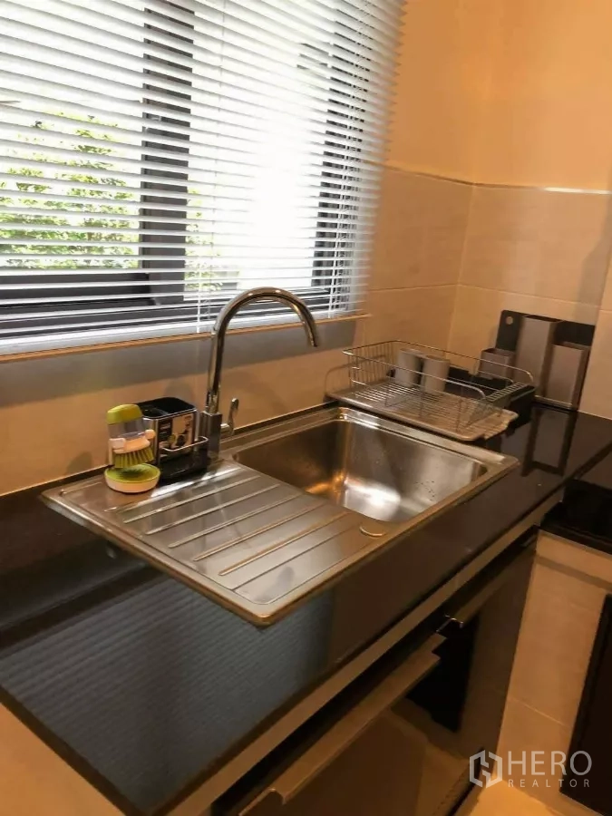 บ้าน ให้เช่าหรือขายในPrawet, Bangkok - อ่างล้างจานใต้หน้าต่างพร้อมมู่ลี่ เคาน์เตอร์ท็อปหินสีดำ