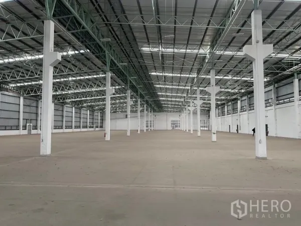 工厂 出租在Bang Sao Thong, Samut Prakan - 宽阔仓库内部，高挑钢桁架屋顶与成排立柱