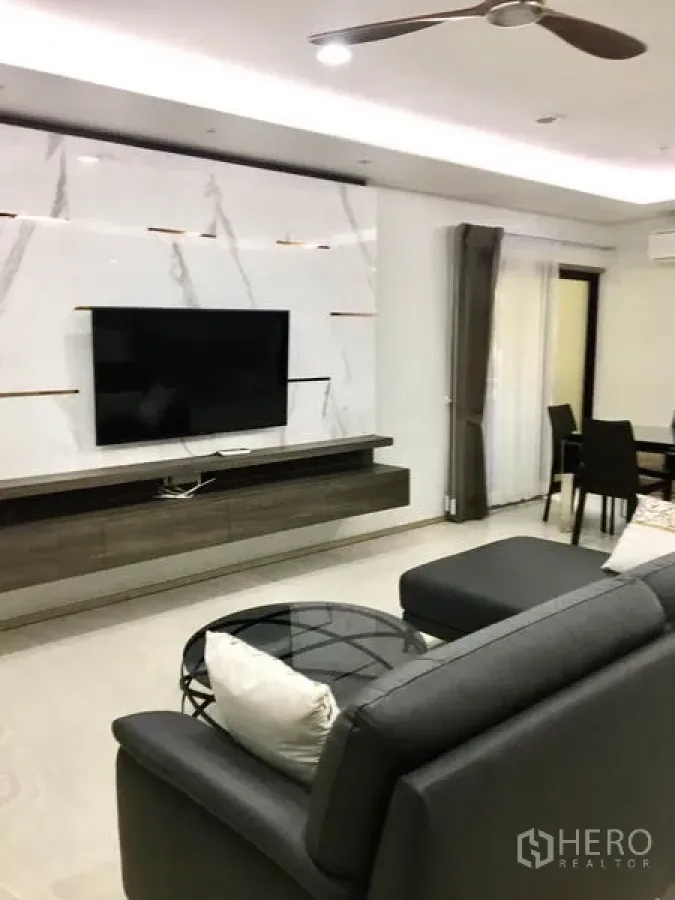 公寓 出租在Watthana, Bangkok - 现代客厅，墙面大理石纹、壁挂电视、灰色沙发与玻璃茶几