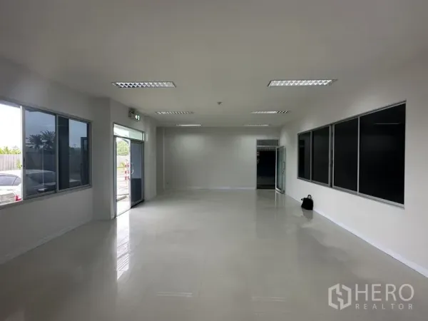 โรงงาน ให้เช่าในBang Phli, Samut Prakan - ออฟฟิศชั้นล่างสว่างโปร่ง หน้าต่างบานใหญ่ พื้นกระเบื้อง และประตูเข้าออกแบบกระจก