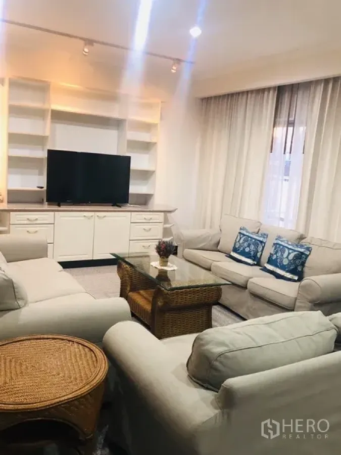 คอนโด ให้เช่าในWatthana, Bangkok - ห้องนั่งเล่นกว้าง โซฟาสีอ่อน ชั้นบิลท์อิน และโต๊ะกลางกระจก