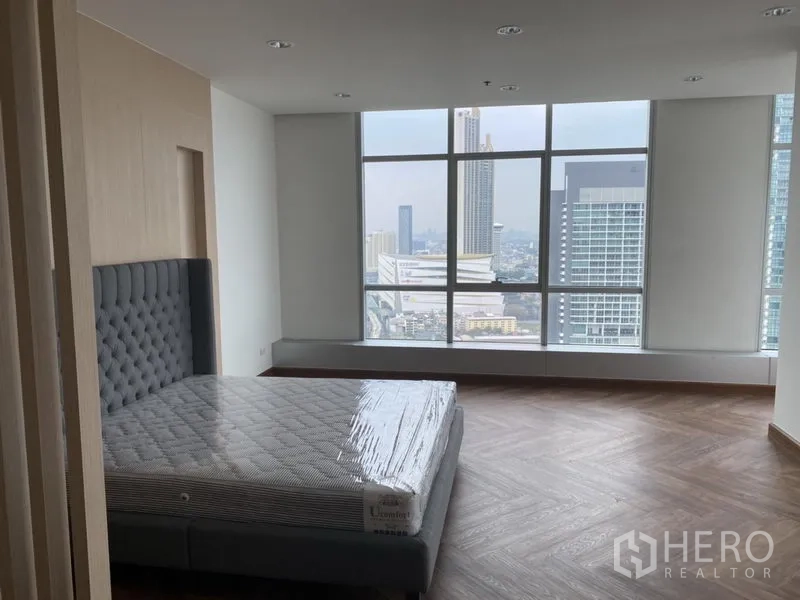 คอนโด ให้เช่าหรือขายในKhlong San, Bangkok - ห้องนอนกว้างพื้นลายก้างปลา หน้าต่างบานใหญ่พร้อมเตียงและวิวเมือง