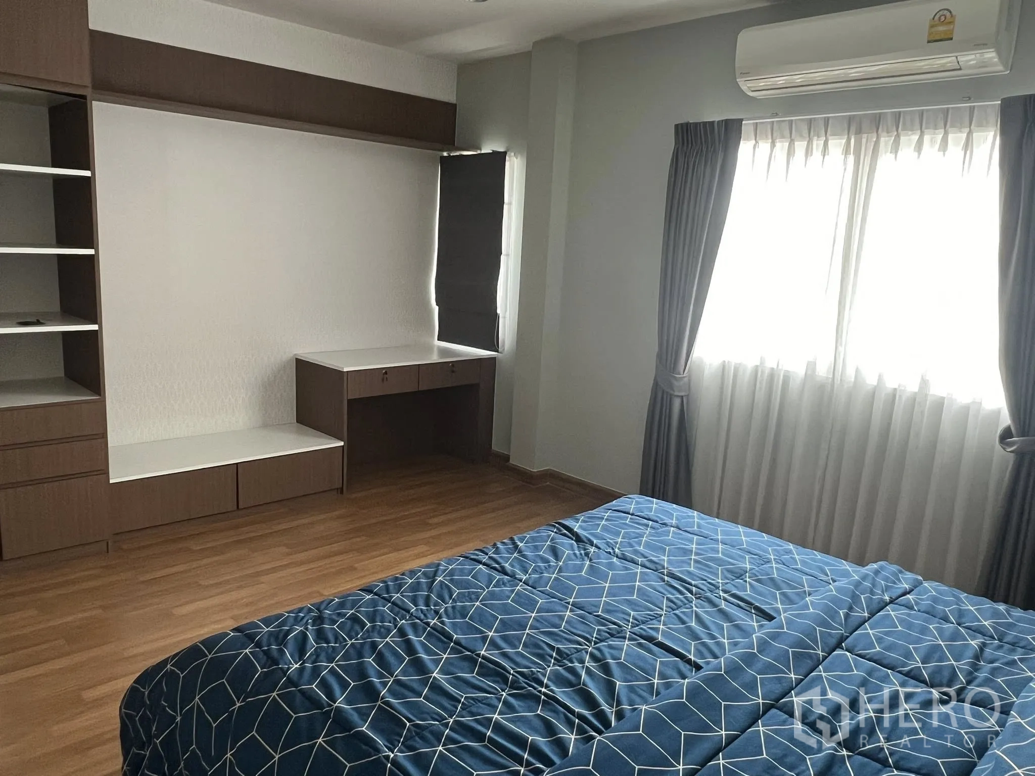 Detached House for rent or sale in Don Mueang, Bangkok - Bright bedroom with built-in desk, bed, curtains and air conditioner.