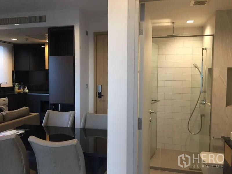 Condominium for rent in Chatuchak, Bangkok - Dining corner beside a bright bathroom featuring a glass-enclosed rain shower.