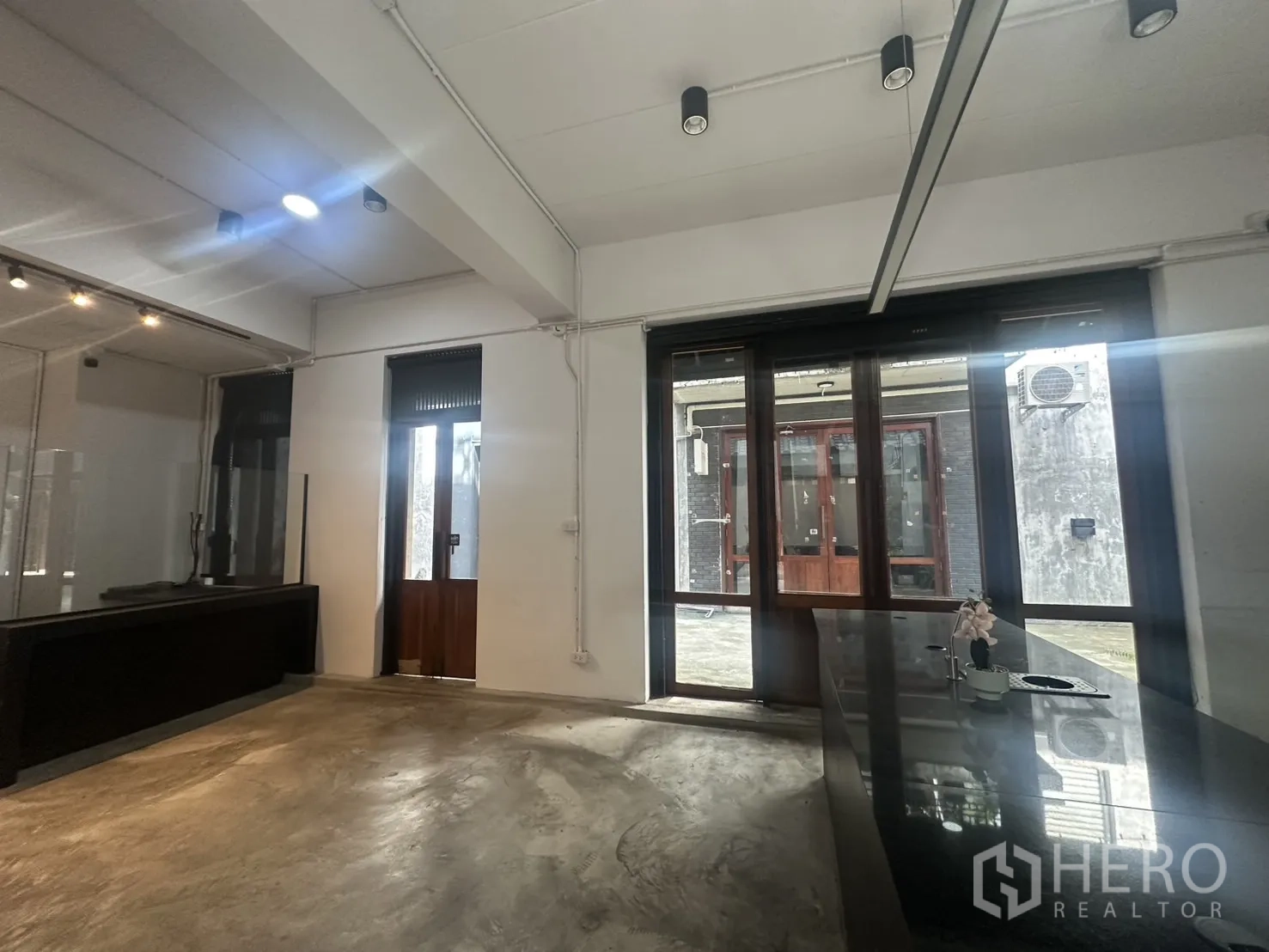 สำนักงานที่บ้าน ให้เช่าในPathum Wan, Bangkok - พื้นที่ชั้นล่างกว้าง เพดานติดรางไฟ และพื้นคอนกรีตเรียบ
