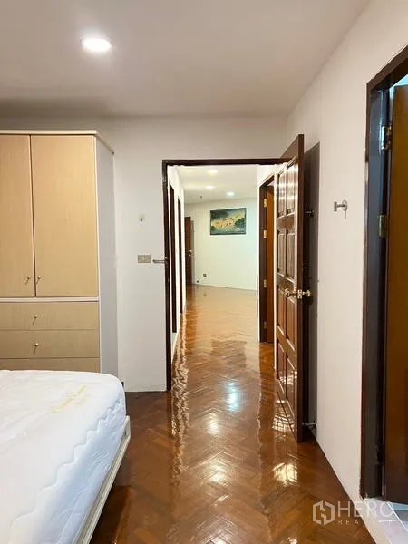 คอนโด ให้เช่าในRatchathewi, Bangkok - มุมมองจากห้องนอนหลักสู่โถงทางเดินสว่าง พื้นไม้ขัดเงา พร้อมตู้บิลท์อิน