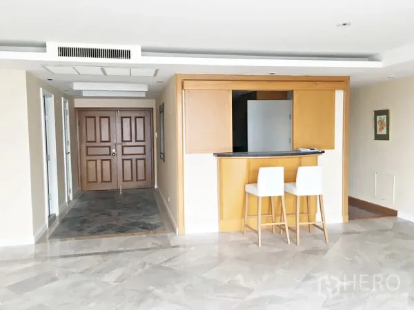 คอนโด ให้เช่าในPathum Wan, Bangkok - โถงทางเข้ากว้าง ประตูไม้คู่ พื้นหินอ่อน พร้อมเคาน์เตอร์บาร์และสตูลสองตัว