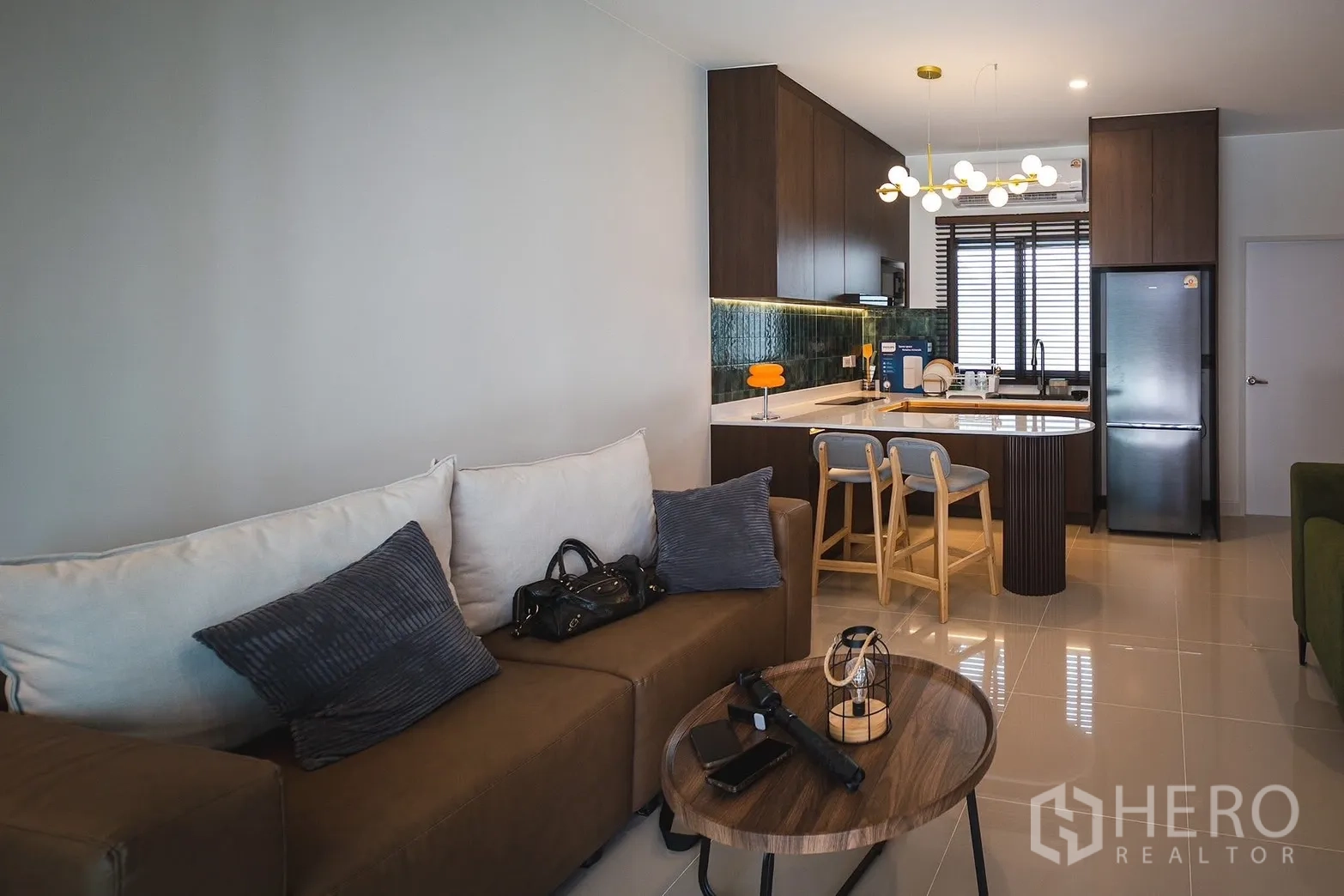 联排别墅 for rent in Bang Phli, Samut Prakan - 从客厅望向带吊灯的厨房岛台与吧椅。