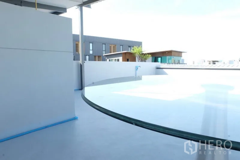 Home Office for rent in Wang Thonglang, Bangkok - Rooftop terrace area with curved wall detail and open city aspect.