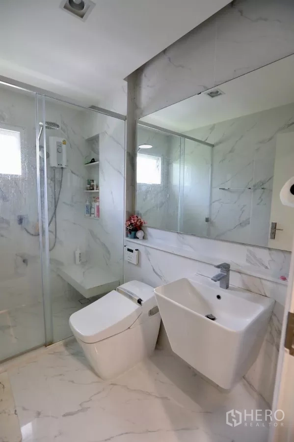 Detached House for rent in Samut Prakan - Close-up of TV feature wall with decorative shelving and LED lighting.