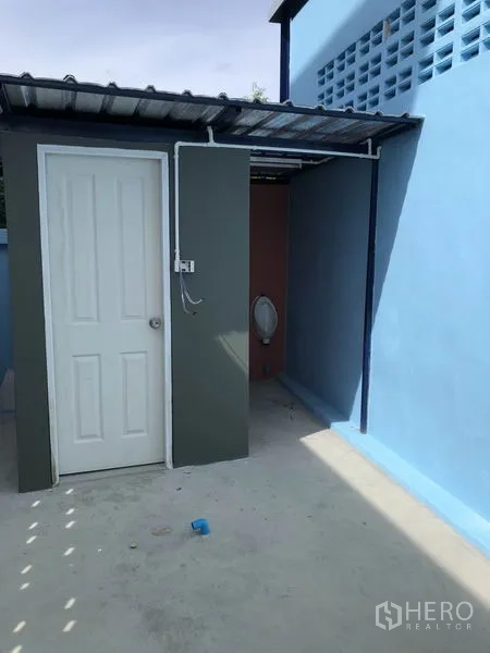 工厂 出租或出售在Bang Bua Thong, Nonthaburi - 建筑侧外部卫生间，带遮雨棚的便池区。