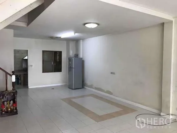 ทาวน์เฮาส์ ให้เช่าในSuan Luang, Bangkok - พื้นที่รับแขกแบบเปิดปูกระเบื้องสีขาว มีโคมไฟเพดานและตู้เย็น เชื่อมต่อไปยังครัว