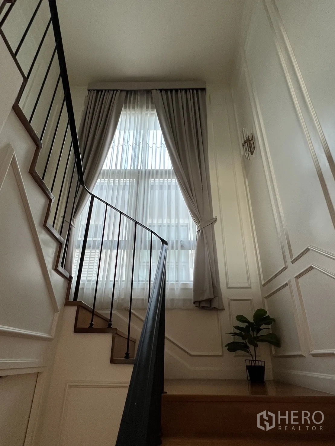 Detached House for rent in Suan Luang, Bangkok - Staircase with metal handrail, tall window and sheer drapes.