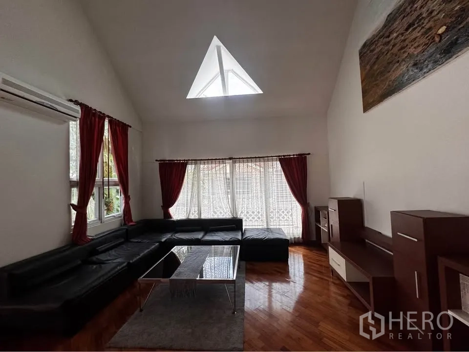 ทาวน์เฮาส์ for rent in Huai Khwang, Bangkok - ห้องนั่งเล่นชั้นบน โซฟาตัวแอล พื้นไม้ และช่องสกายไลท์รูปสามเหลี่ยม.