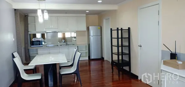คอนโด ให้เช่าในWatthana, Bangkok - โซนรับประทานอาหารสว่างข้างครัวบิลท์อินสีขาว มีโคมไฟ หยุดตู้เย็น และชั้นวางบนพื้นไม้ขัดเงา
