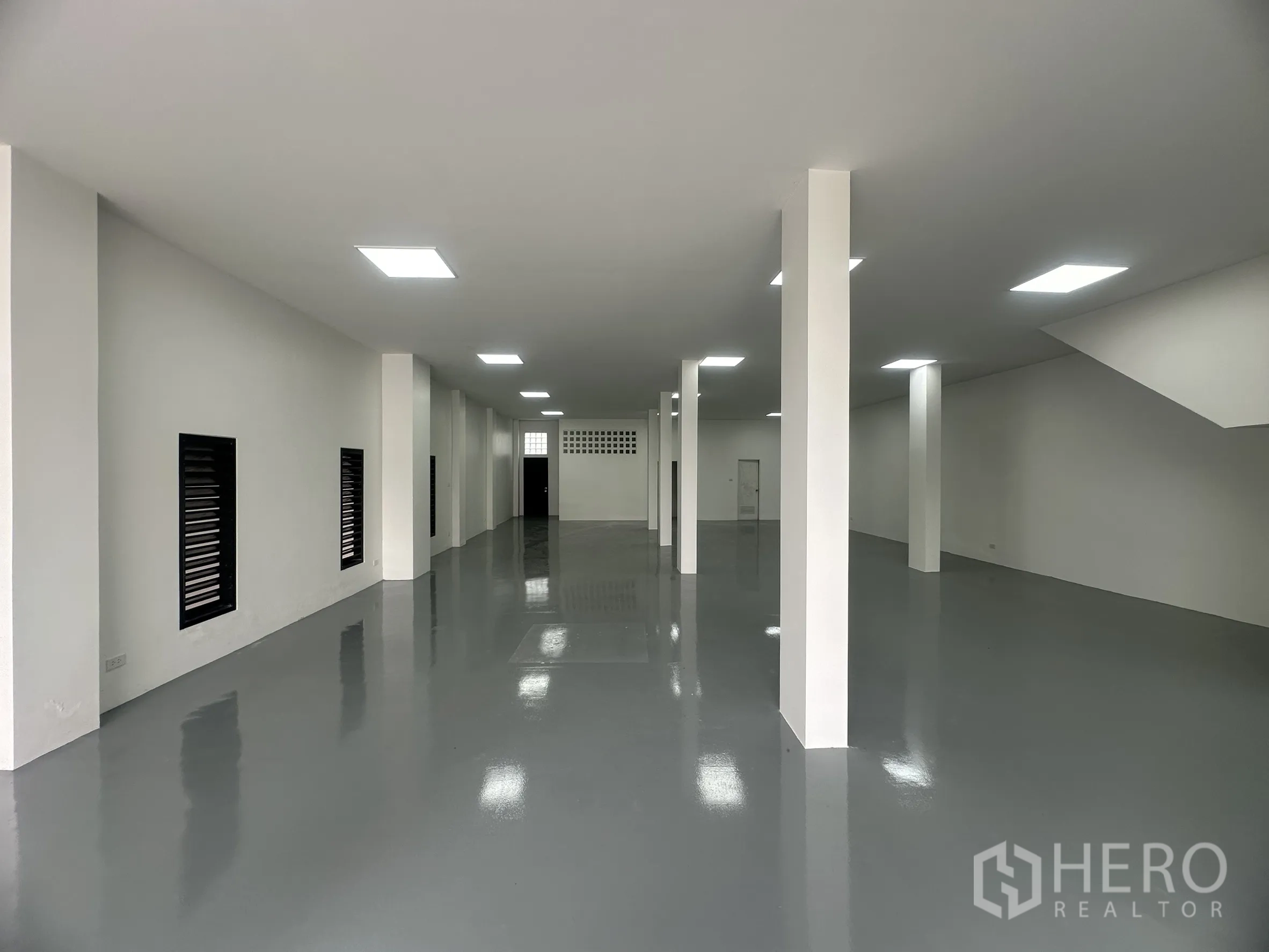 คลังสินค้า ขายในKhlong Luang, Pathum Thani - ภายในโกดังพื้นอีพ็อกซี่สีเทา ผนังสีขาว มีเสาและไฟ LED สว่าง