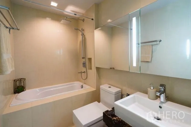 คอนโด ให้เช่าในWatthana, Bangkok - ห้องน้ำดีไซน์เรียบหรูพร้อมอ่างอาบน้ำ ฝักบัวเรนชาวเวอร์ และตู้กระจก