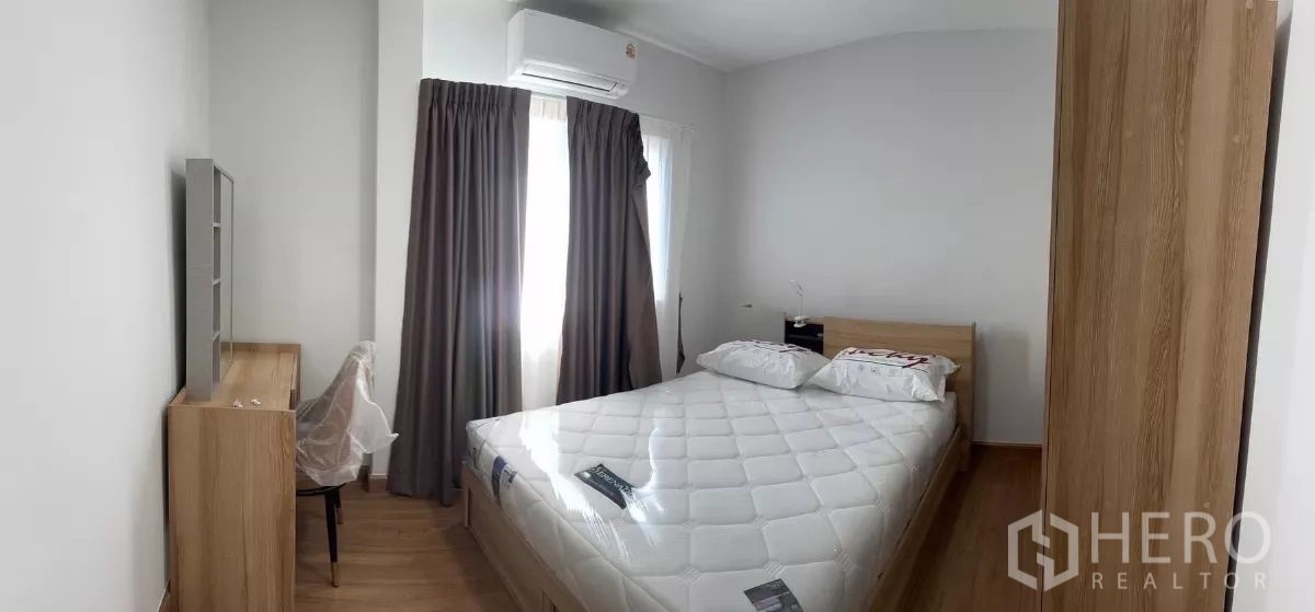 Detached House for rent in Bang Phli, Samut Prakan - Second bedroom with double bed, desk, wardrobe and corner windows with curtains.