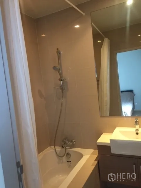 คอนโด ให้เช่าในBangkok - ห้องน้ำพร้อมอ่างอาบน้ำ-ฝักบัว กระจกบานใหญ่ และอ่างล้างหน้าแบบโมเดิร์น