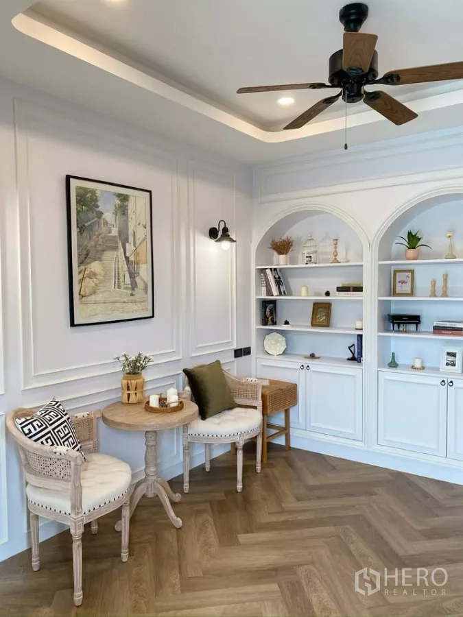 独立式住宅 出售在Sai Mai, Bangkok - 阅读区，吊扇、拱形书架与墙面线条装饰。