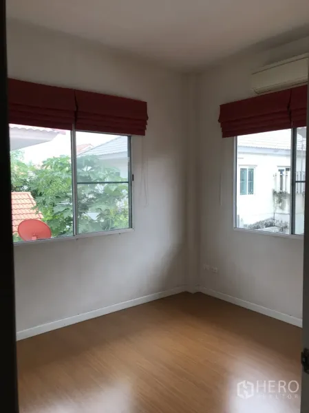 บ้าน ให้เช่าในLat Krabang, Bangkok - ห้องนอนมุมห้อง มีหน้าต่างสองบาน ม่านพับสีแดง พื้นลายไม้