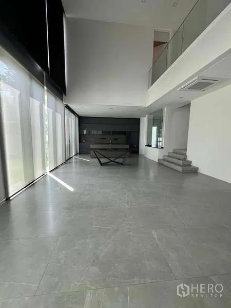 Detached House for sale in Bang Phli, Samut Prakan - Double-height living area with floor-to-ceiling windows and minimalist grey tile floors.