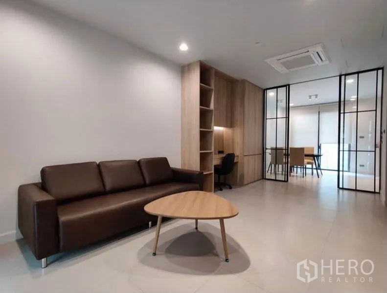 ทาวน์เฮาส์ ให้เช่าในSuan Luang, Bangkok - สเปซนั่งเล่นแบบเปิดโล่ง โซฟาหนัง ชั้นบิวท์อินไม้ และมุมทำงาน