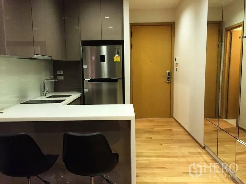 คอนโด ให้เช่าหรือขายในWatthana, Bangkok - ครัวสไตล์โมเดิร์นพร้อมเคาน์เตอร์บาร์ เก้าอี้สตูล กระจกเงาบานใหญ่ และประตูไม้